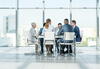 a group of business people sitting at a table for a meeting